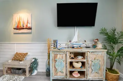 a living room with a tv on a wall at Shores of Panama 2024 in Panama City Beach
