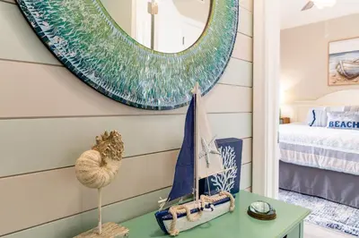 a bedroom with a mirror and a table with a bed at Shores of Panama 2024 in Panama City Beach
