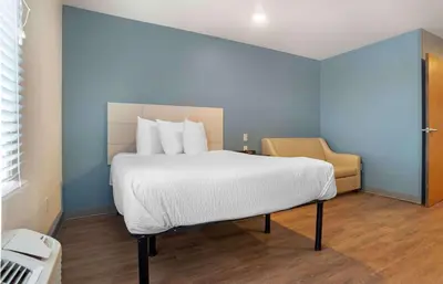 a bedroom with a large bed and a chair at Extended Stay America Select Suites - Panama City - Callaway in Callaway