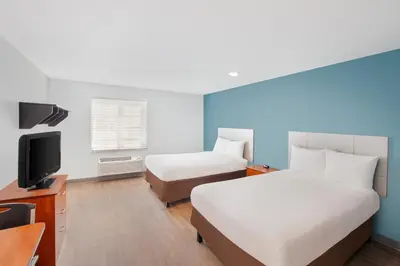 a hotel room with two beds and a tv at Extended Stay America Select Suites - Panama City - Callaway in Callaway