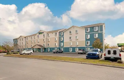 a large building with cars parked in a parking lot at Extended Stay America Select Suites - Panama City - Callaway in Callaway