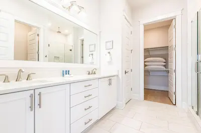 a white bathroom with two sinks and a large mirror at Happily Eva After at Prominence 30A in Inlet Beach