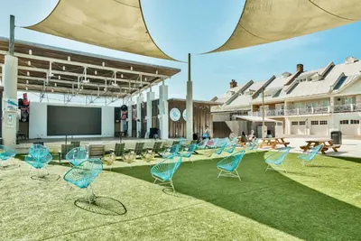 a group of blue chairs sitting on the grass at Happily Eva After at Prominence 30A in Inlet Beach