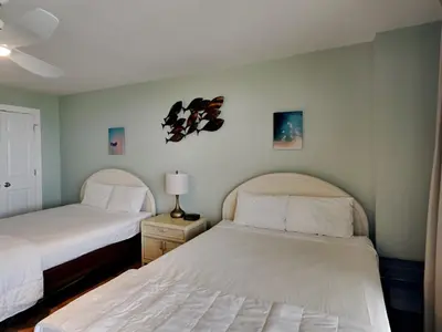 a bedroom with two beds and a lamp on a night stand at Watercrest 1401 in Panama City Beach