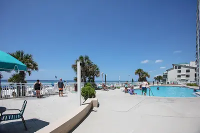 people standing around a swimming pool next to the beach at Watercrest 1401 in Panama City Beach