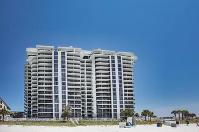a large apartment building on the beach with a beach at Watercrest 1401 in Panama City Beach