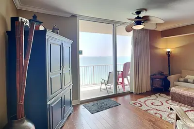 a living room with a ceiling fan and a balcony at Tidewater Beach Resort #2607 in Panama City Beach