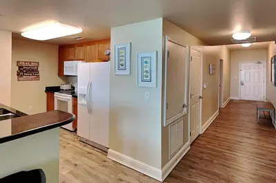 a kitchen with a white refrigerator in a room at Aqua 404 in Panama City Beach