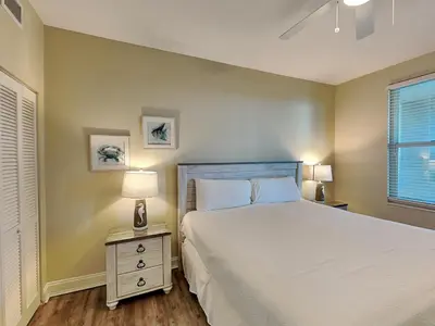 a bedroom with a bed and a lamp on a night stand at Aqua 404 in Panama City Beach