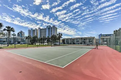 a tennis court with clouds in the sky at Walk to Beach PCB Condo with Oceanfront Pool Access in Panama City Beach