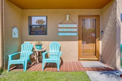 two blue chairs and a table on a patio at Walk to Beach PCB Condo with Oceanfront Pool Access in Panama City Beach