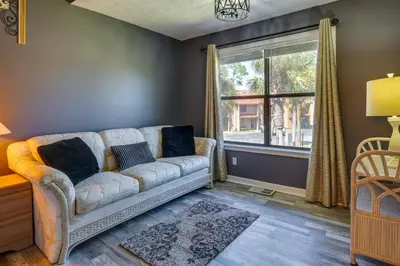 a living room with a couch and a window at Walk to Beach PCB Condo with Oceanfront Pool Access in Panama City Beach