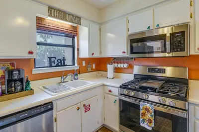 a kitchen with a stove and a sink and a microwave at Walk to Beach PCB Condo with Oceanfront Pool Access in Panama City Beach