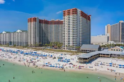 a group of people on a beach with buildings at Shores of Panama Resort, Direct Beachfront, 1 BR plus Bunks! by Dolce Vita Getaways PCB in Panama City Beach