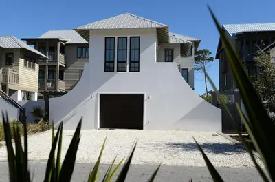 a white house with a garage and some houses at Beautiful High End One Bed / 1 Bath Carriage House in Rosemary Beach