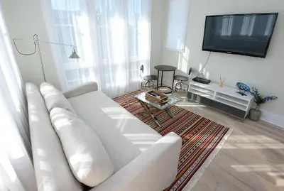 a living room with a white couch and a flat screen tv at Beautiful High End One Bed / 1 Bath Carriage House in Rosemary Beach