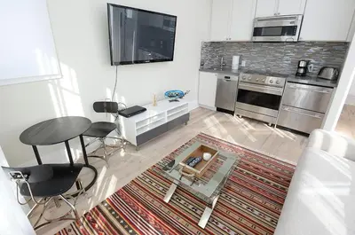 a living room with a table and a kitchen at Beautiful High End One Bed / 1 Bath Carriage House in Rosemary Beach