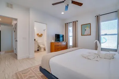 a white bedroom with a bed and a television at Panama City Beach House - The Starfish by Panhandle Getaways in Panama City Beach