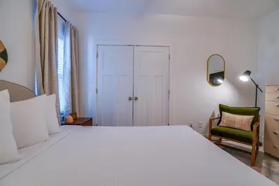 a bedroom with a large white bed and a chair at Panama City Beach House - The Starfish by Panhandle Getaways in Panama City Beach