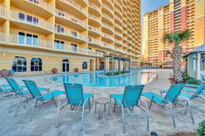 a hotel patio with chairs and a swimming pool at Calypso Resort Tower 3 by Panhandle Getaways in Panama City Beach