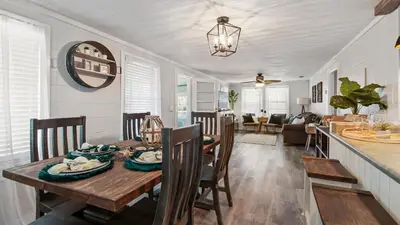 a dining room and living room with a table and chairs at Delmar Dunes by Sand Seeker Vacations in Panama City Beach
