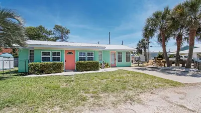 a house with colorful doors and palm trees at Delmar Dunes by Sand Seeker Vacations in Panama City Beach