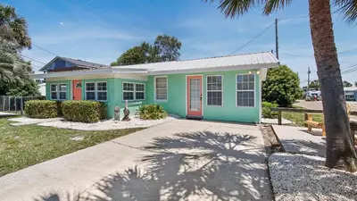 a colorful house with a palm tree in front of it at Delmar Dunes by Sand Seeker Vacations in Panama City Beach