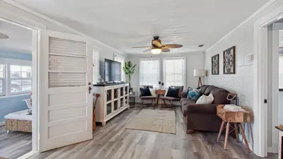 a living room with a couch and a ceiling fan at Delmar Dunes by Sand Seeker Vacations in Panama City Beach