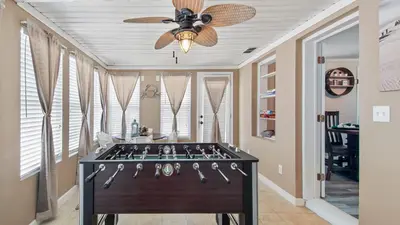 a room with a pool table with a ceiling fan at Delmar Dunes by Sand Seeker Vacations in Panama City Beach