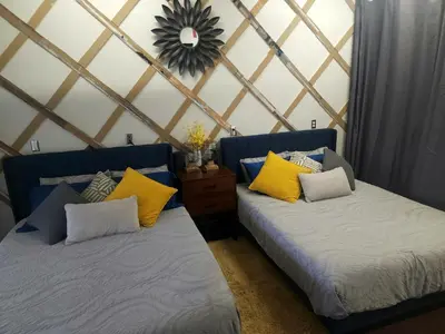 a room with two beds and a mirror on the wall at Hidden Gem Guest House in Panama City Beach