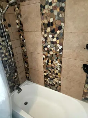 a white bath tub in a bathroom with a mosaic wall at Hidden Gem Guest House in Panama City Beach