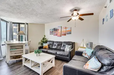 a living room with a couch and a table at Beachfront Panama City Condo with Balcony and Views! in Panama City Beach