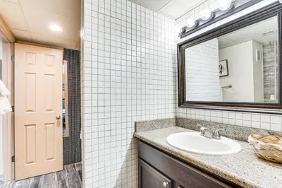 a bathroom with a sink and a mirror at Beachfront Panama City Condo with Balcony and Views! in Panama City Beach