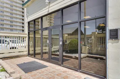 an entrance to a building with glass doors at Beachfront Panama City Condo with Balcony and Views! in Panama City Beach