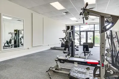a fitness room with tread machines and a mirror at Beachfront Panama City Condo with Balcony and Views! in Panama City Beach
