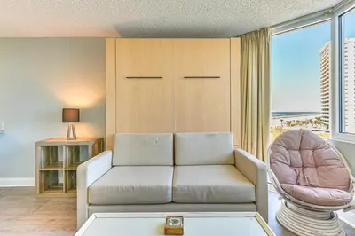 a living room with a couch and a chair at PCB Coastal Condo with On-Site Beach Access! in Panama City Beach
