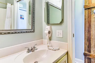 a bathroom with a sink and a hair dryer at PCB Coastal Condo with On-Site Beach Access! in Panama City Beach