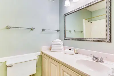 a bathroom with a sink and a mirror at PCB Coastal Condo with On-Site Beach Access! in Panama City Beach