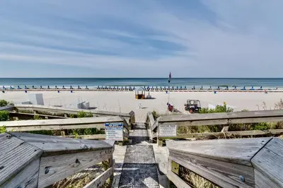 a stairway leading to the beach with a boardwalk at AQUA RESORT! Beachfront, 3 Bedroom Condo! 2 Bedrooms Beach Front! Sleeps 7! Free Beach Chairs by Dolce Vita Getaways PCB in Panama City Beach