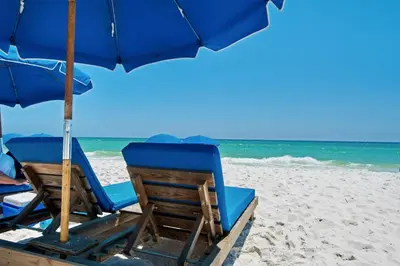 two chairs and an umbrella on a beach at AQUA RESORT! Beachfront, 3 Bedroom Condo! 2 Bedrooms Beach Front! Sleeps 7! Free Beach Chairs by Dolce Vita Getaways PCB in Panama City Beach