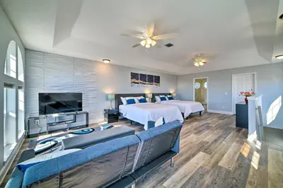 a hotel room with two beds and a flat screen tv at Sunny PCB Home with Balcony Steps to the Beach! in Panama City Beach