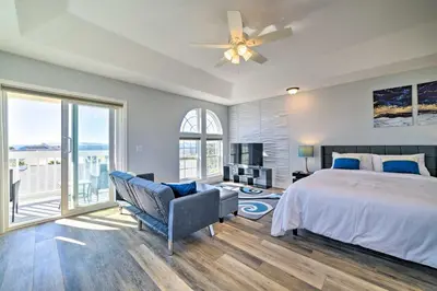 a bedroom with a bed and a large window at Sunny PCB Home with Balcony Steps to the Beach! in Panama City Beach