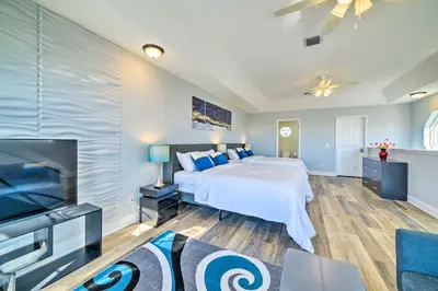 a large bedroom with a bed and a tv at Sunny PCB Home with Balcony Steps to the Beach! in Panama City Beach