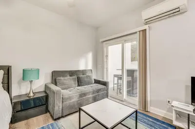 a living room with a couch and a window at Renovated PCB Studio, 2 Min Walk To Laguna Beach! in Panama City Beach