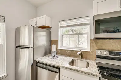 a kitchen with a stainless steel refrigerator and a sink at Renovated PCB Studio, 2 Min Walk To Laguna Beach! in Panama City Beach