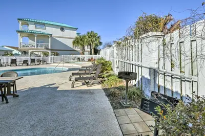 a fence with benches next to a swimming pool at Renovated PCB Studio, 2 Min Walk To Laguna Beach! in Panama City Beach