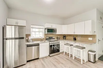 a kitchen with white cabinets and stainless steel appliances at Renovated PCB Studio, 2 Min Walk To Laguna Beach! in Panama City Beach
