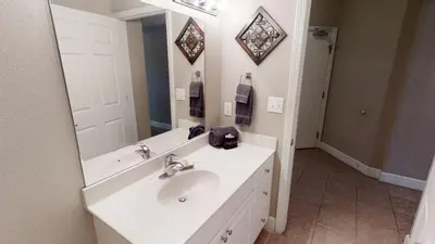 a bathroom with a white sink and a mirror at Tidewater 1102 in Panama City Beach