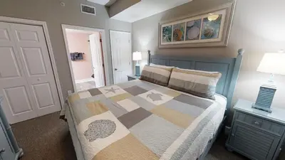 a bedroom with a bed with a quilt on it at Tidewater 704 in Panama City Beach