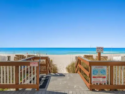 a wooden walkway to the beach with the ocean at Regency Towers 505 in Panama City Beach